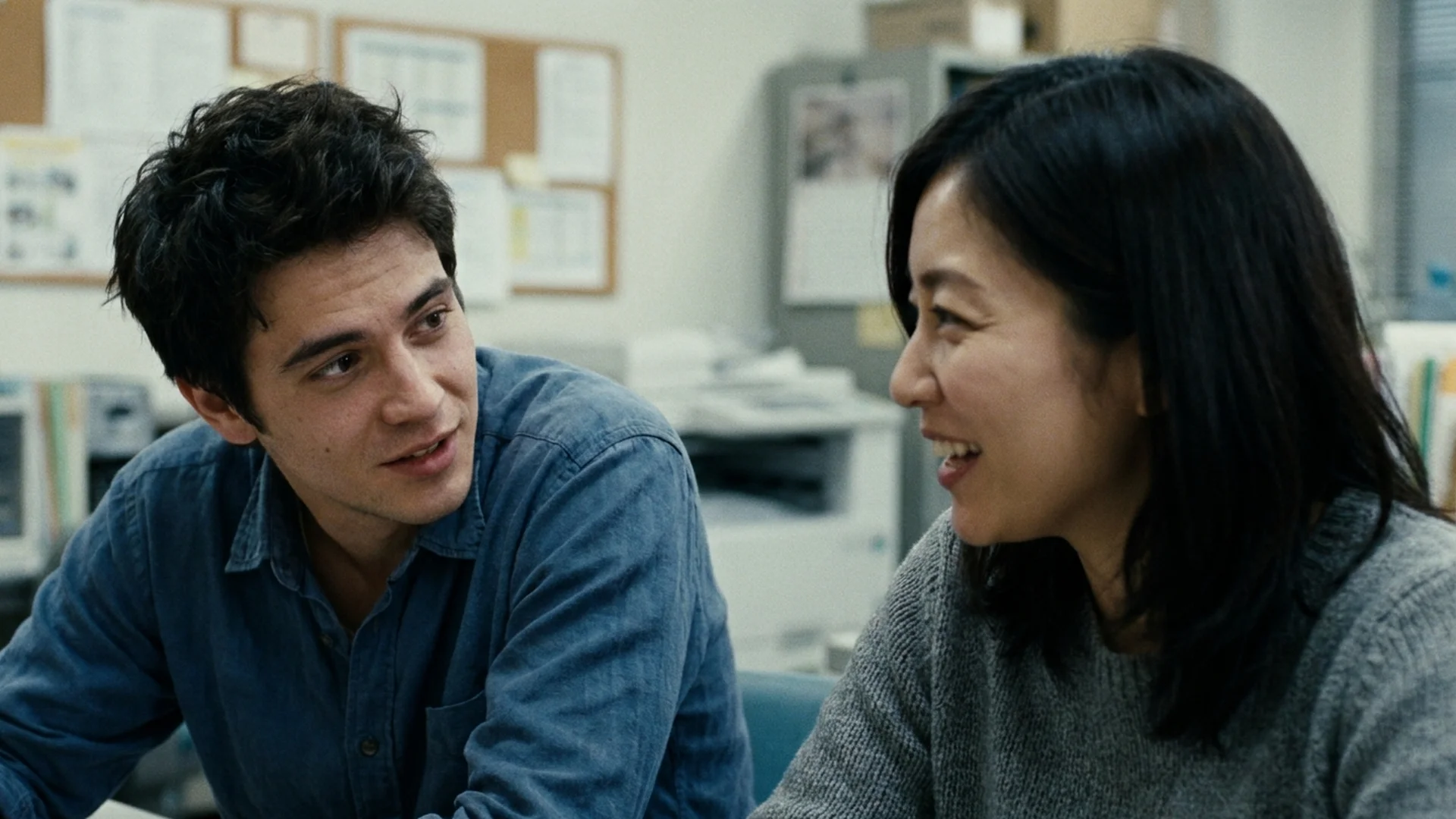 A learner listening closely to a Japanese coworker talking in an office